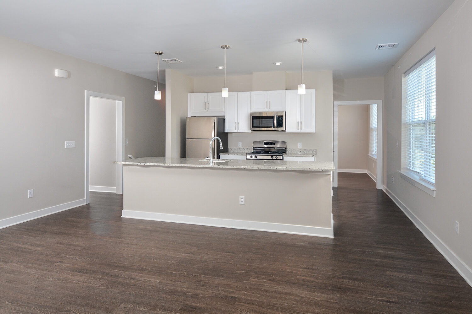 Open floorplan kitchen and living room with plank flooring and kitchen island