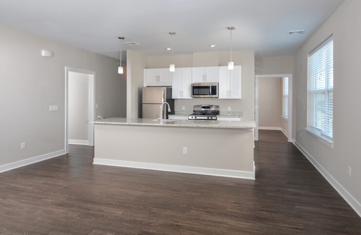 Open floorplan kitchen and living room with plank flooring and kitchen island 
