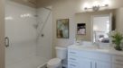 bathroom with tile shower and white vanity 