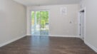 living room with plank flooring and sliding doors leading out to the balcony 