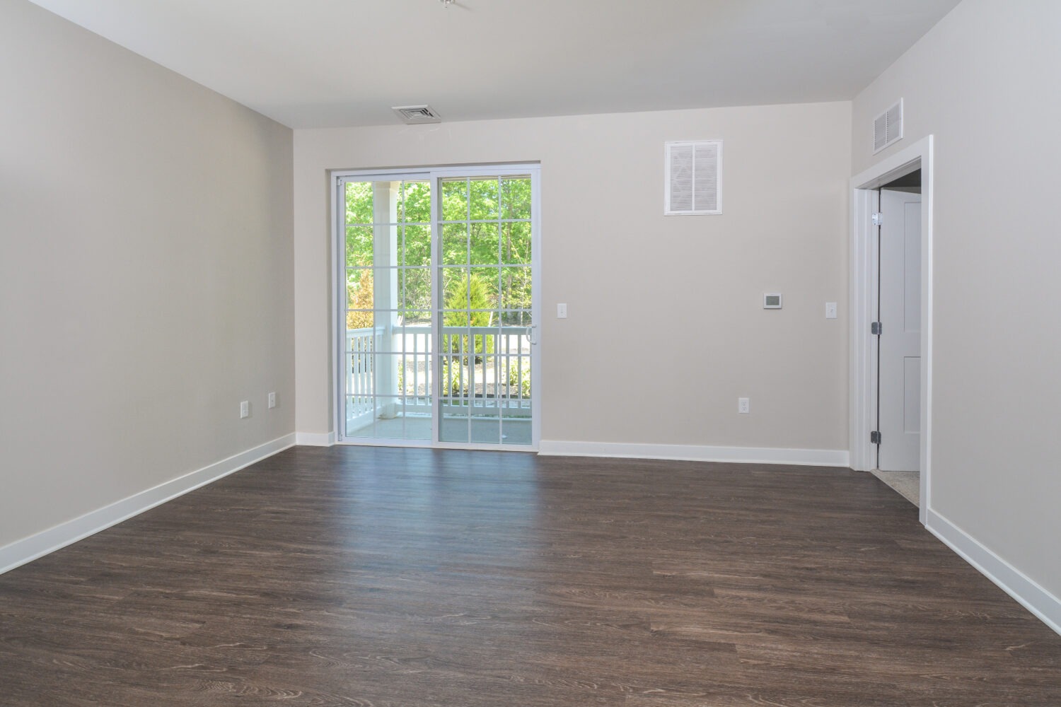 living room with plank flooring and sliding doors leading out to the balcony