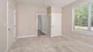 master bedroom with large window and neutral carpet 