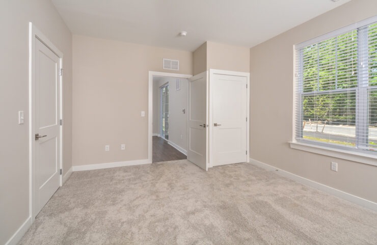 master bedroom with large window and neutral carpet 