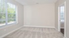 bedroom with large window and neutral color carpet