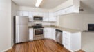 upgraded kitchen comes with white cabinets and stainless steel appliances