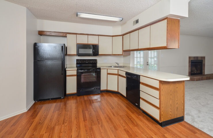 standard kitchen with black appliances and plank flooring