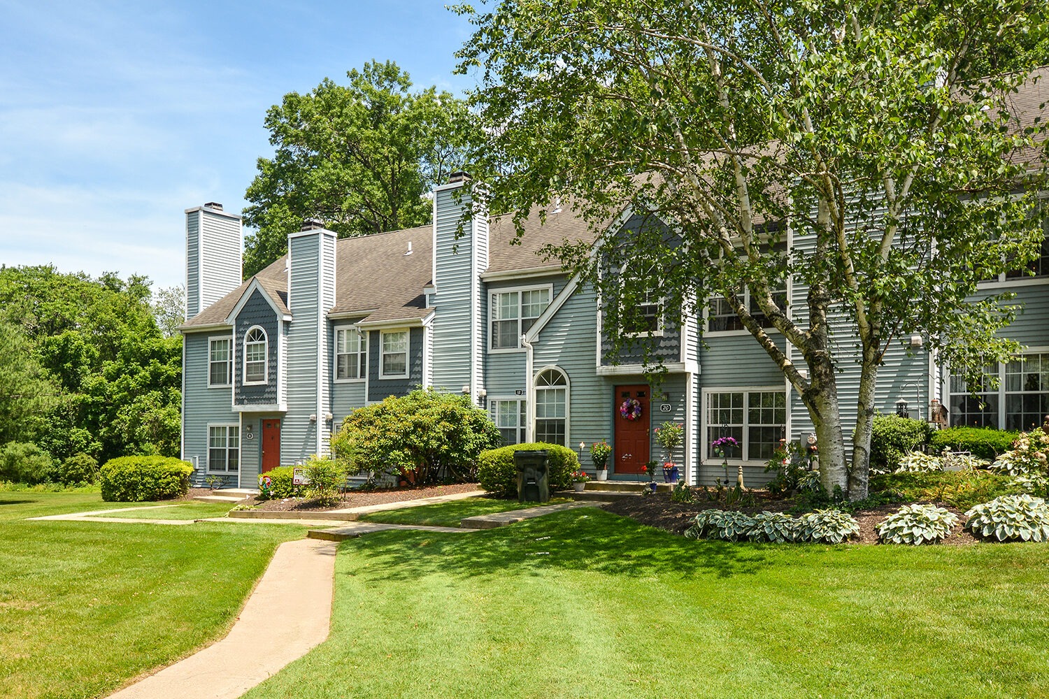entrances to townhomes with lush green landscaping