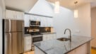 Modern Kitchen With Stainless Steel Appliances, Granite Countertops and Designer Lighting