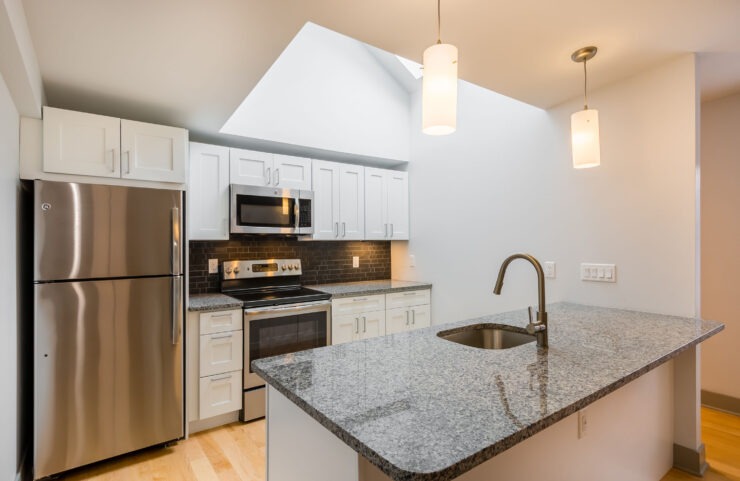 Modern Kitchen With Stainless Steel Appliances, Granite Countertops and Designer Lighting