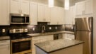 Modern Kitchen With Stainless Steel Appliances, Granite Countertops and Designer Lighting