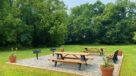 large grassy area with picnic tables and grills