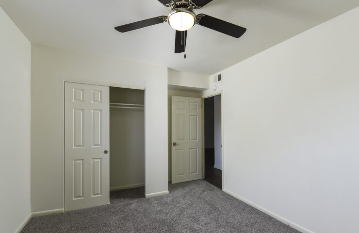 Bedroom with large closet and ceiling fan