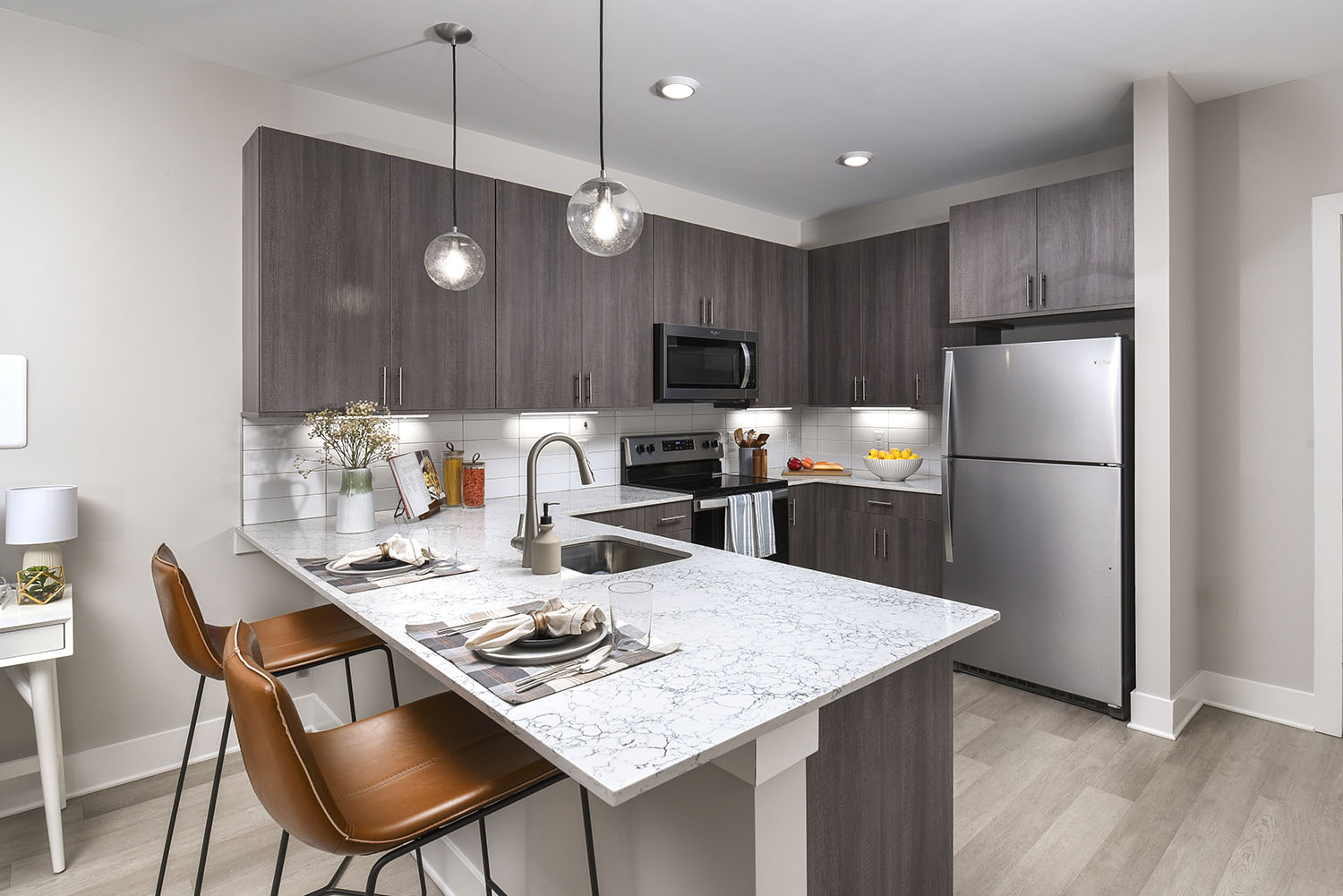kitchen with breakfast bar, plank floors and quartz countertops