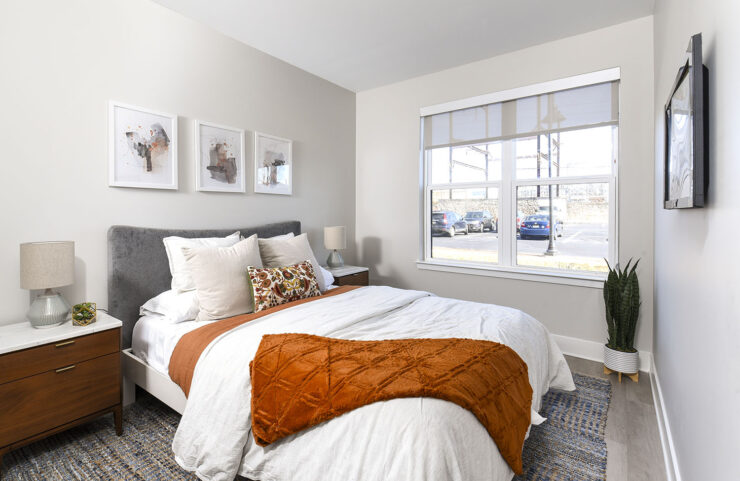 bedroom with large window and plank flooring 