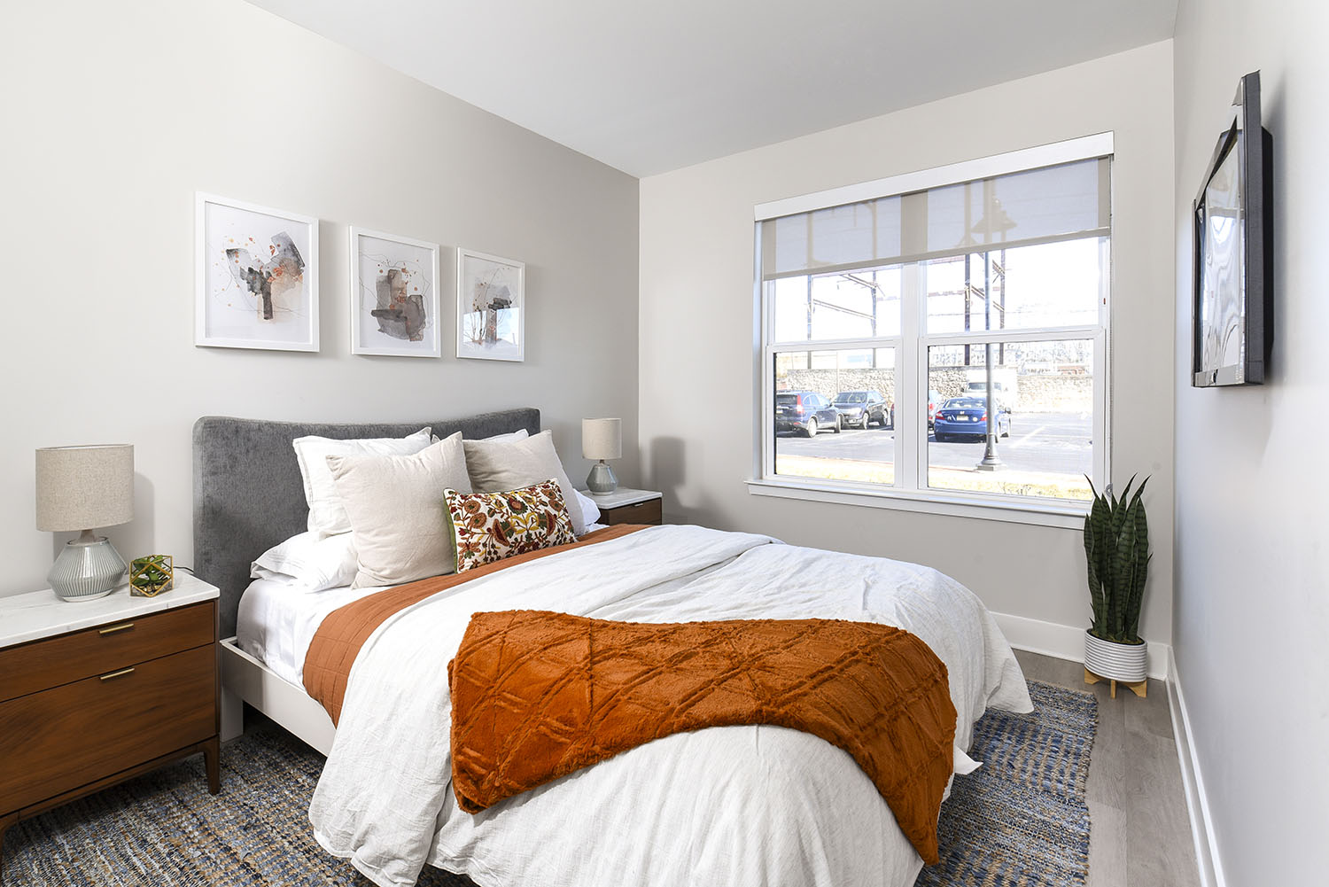 bedroom with large window and plank flooring 