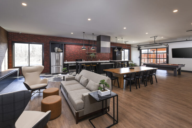 Great room with demonstration kitchen, lounge seating, and convertible garage style doors for open-air enjoyment 
