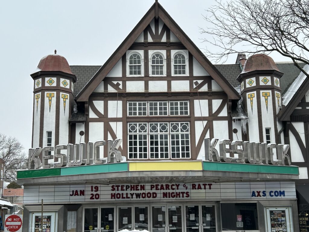 A brown and white building with the words "Keswick" on either side, green and yellow accents high up near the roof