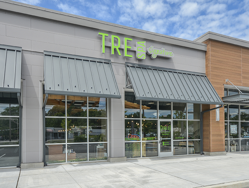A gray building with a lime green sign that reads "Tre Spa Signature"