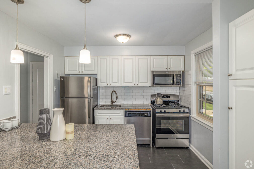 Kitchen with stainless steel appliances, granite countertops, and overhead lights.