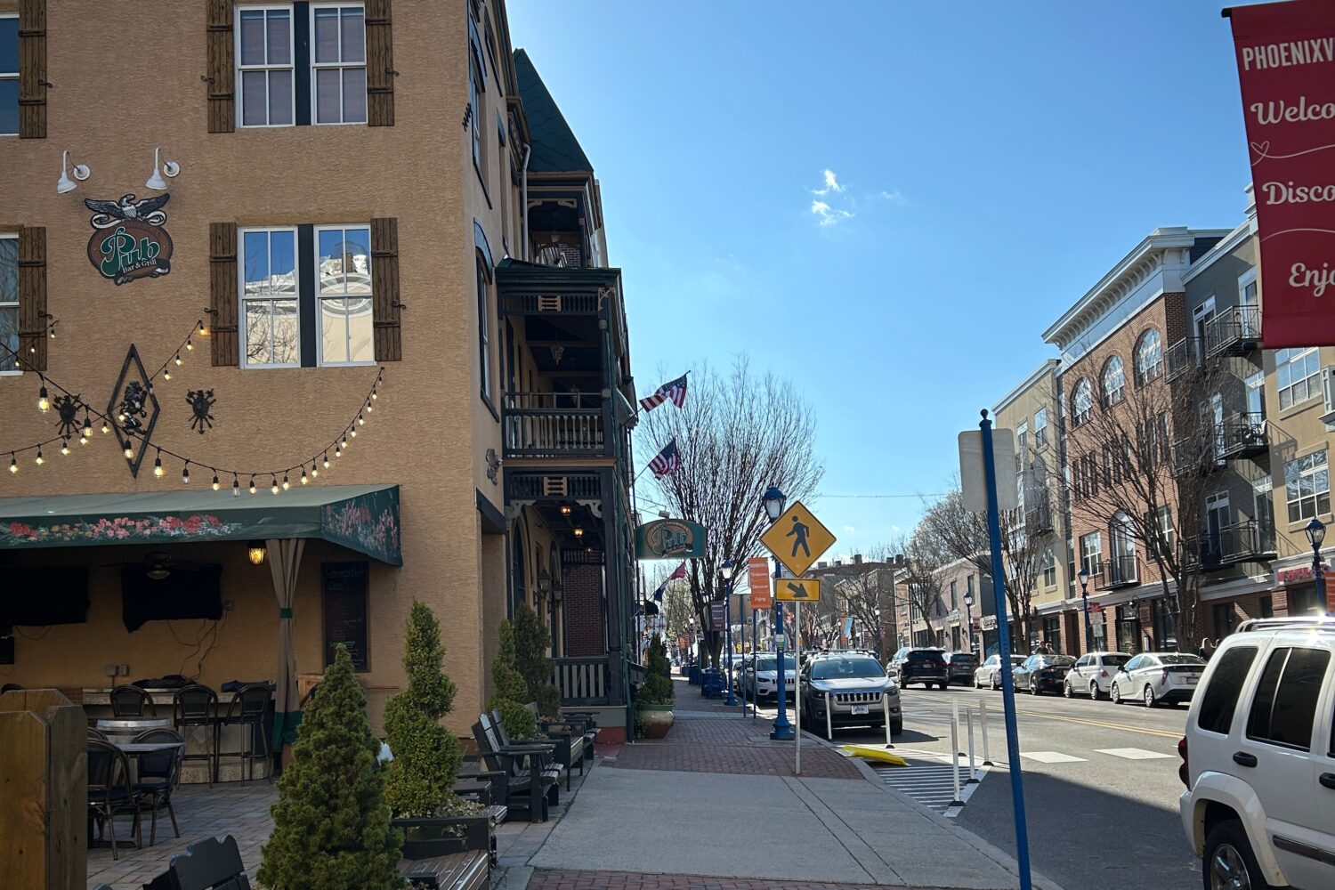 Sidewalk on Phoenixville's Main Street next to a pub and a crosswalk