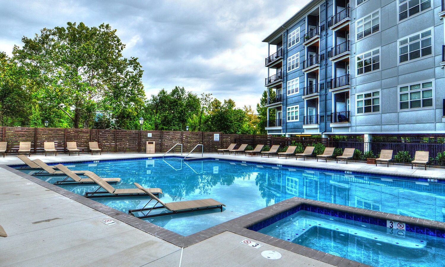 Resort-style swimming pool with sun shelf and hot tub