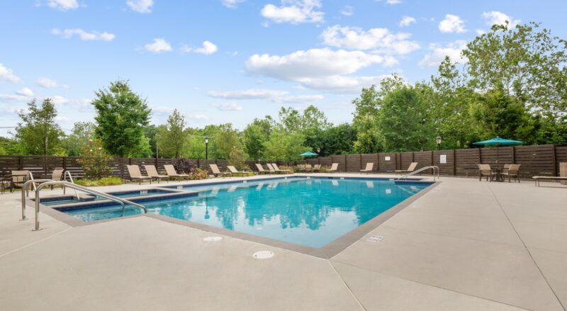 Resort-style swimming pool with sun shelf and hot tub