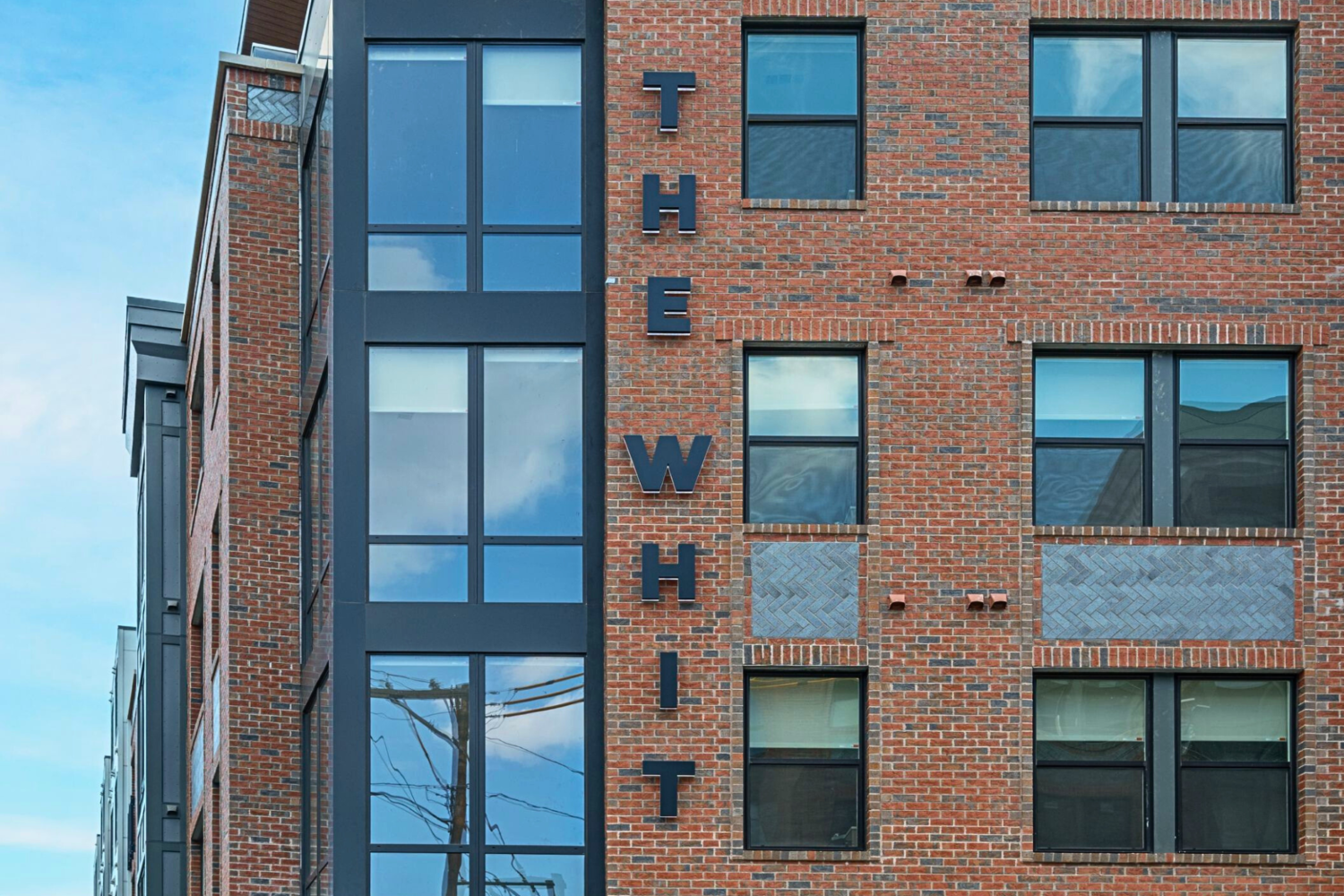 A brick building with the words The Whit written vertically