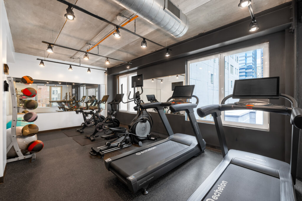A fitness center with cardio machines and medicine balls