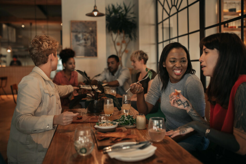 Group of friends at a restaurant eating and laughing together
