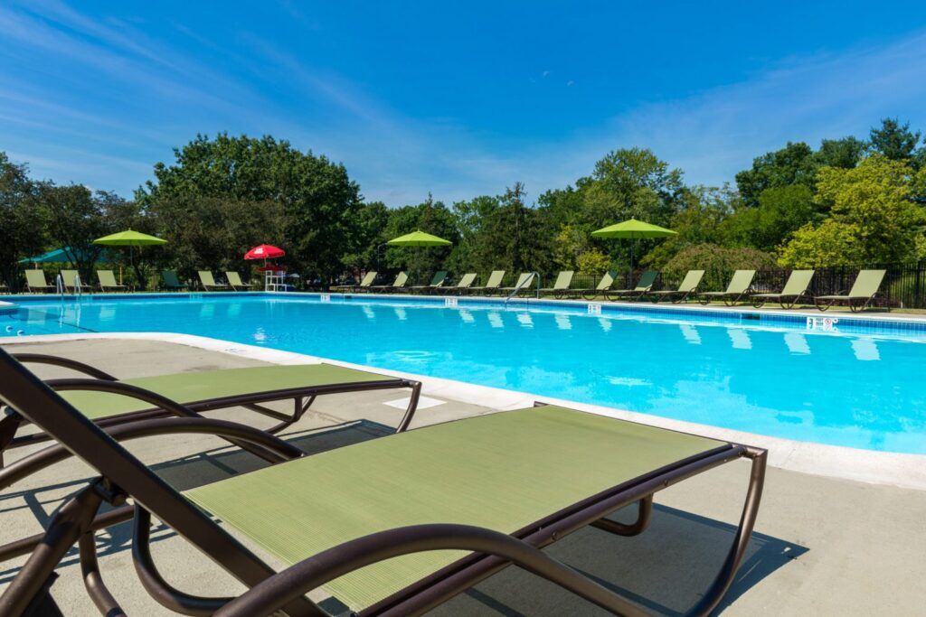 Large swimming pool with lounge chairs at Hatfield Village Apartments