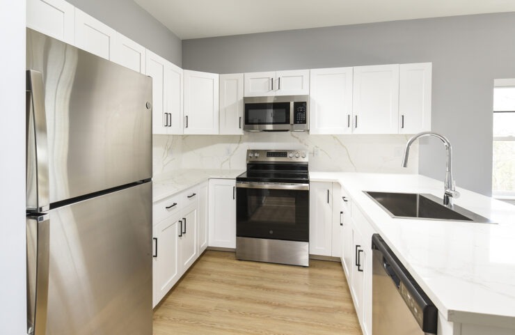 Kitchen With Efficient, Modern Stainless Steel Appliances and Quartz Countertops and Pendant Lighting