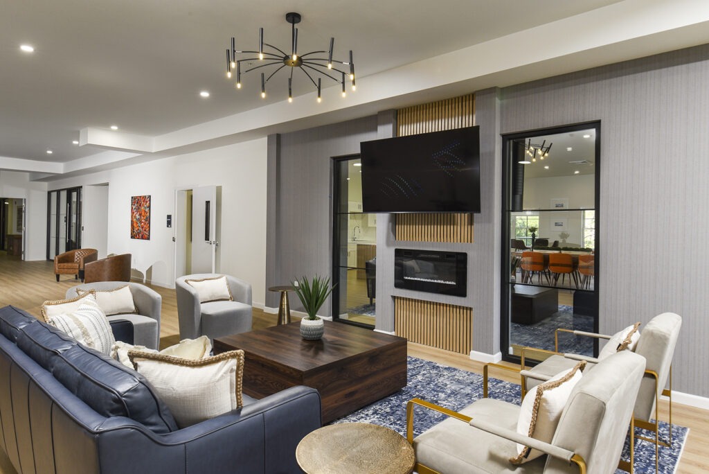 Resident lounge with a television, couches, and warm lights