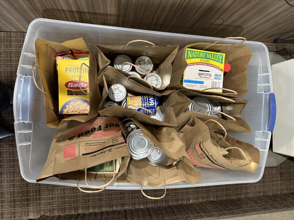 Clear container full of several bags of non-perishable food items
