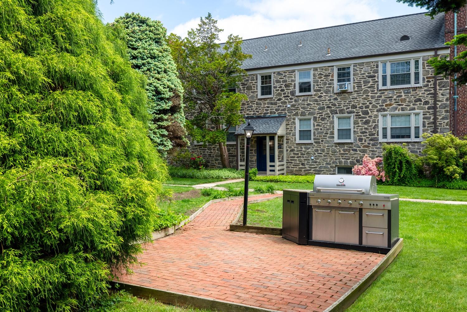 Lush green surroundings with beautiful stone building in the background and a grilling area