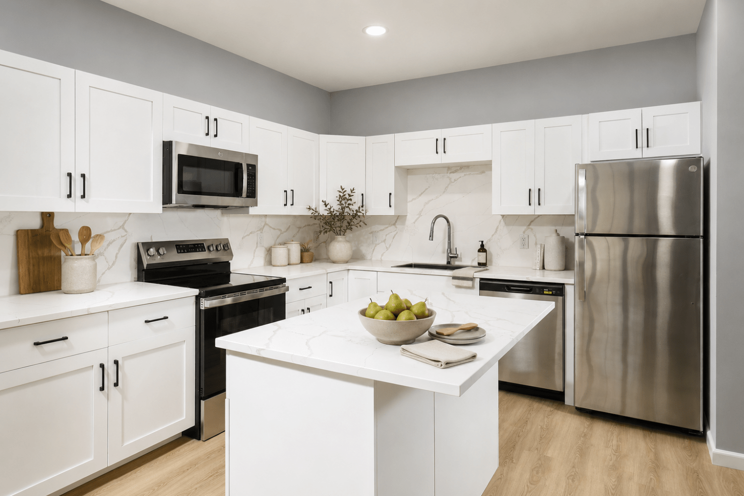 Kitchen With Efficient, Modern Stainless Steel Appliances and Quartz Countertops and Pendant Lighting