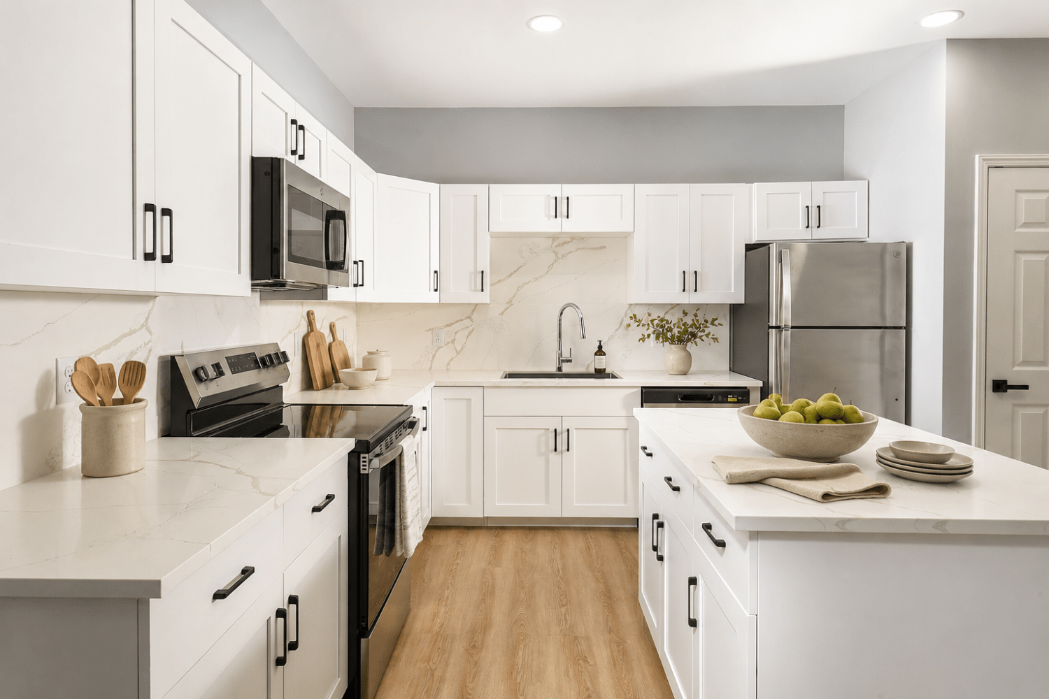 Kitchen With Efficient, Modern Stainless Steel Appliances and Quartz Countertops and Pendant Lighting