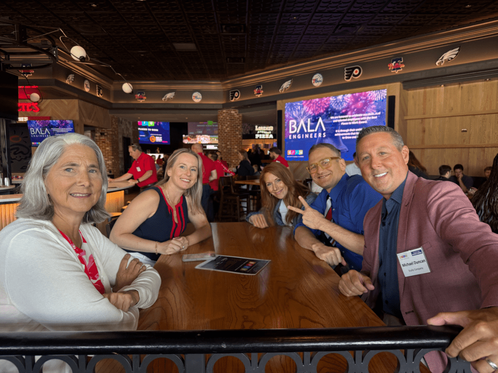 Five Scully Company employees sitting at a table smiling