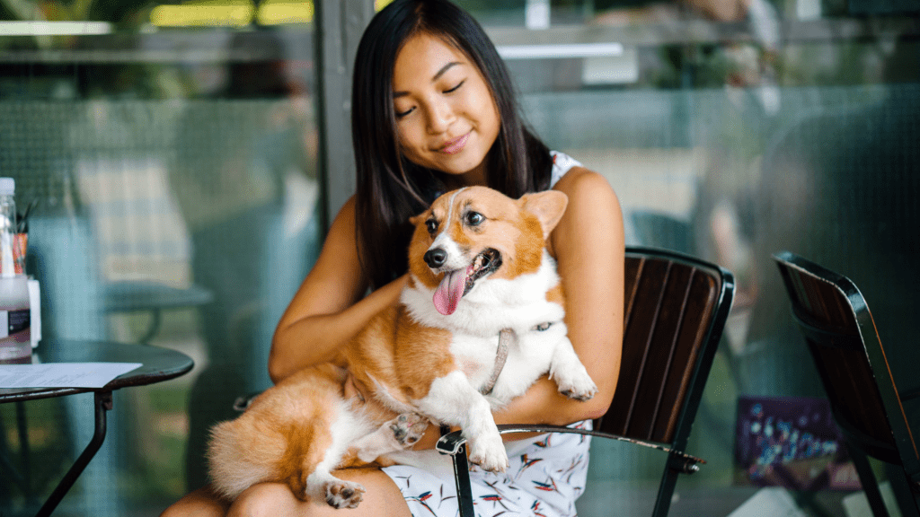 Woman holding dog at an outdoor cafe