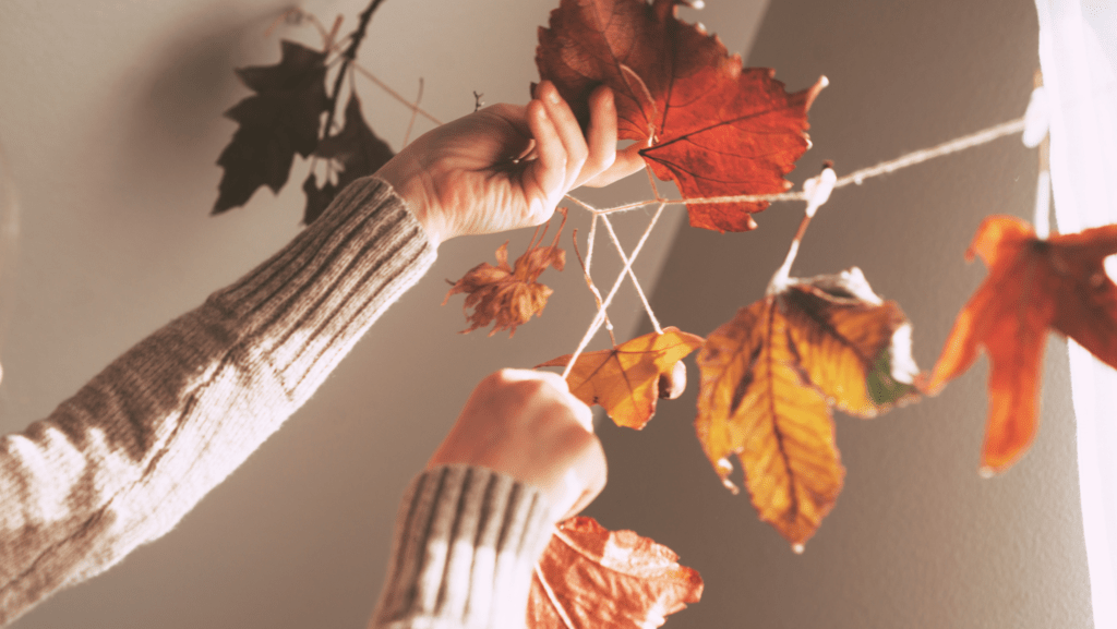 Hands putting up fall decorations in an apartment